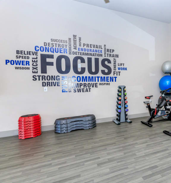 a fitness room with exercise bikes and a tv