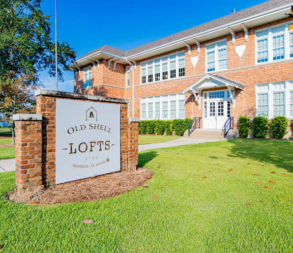 A brick building with a sign that says Old Shell-Lofts.