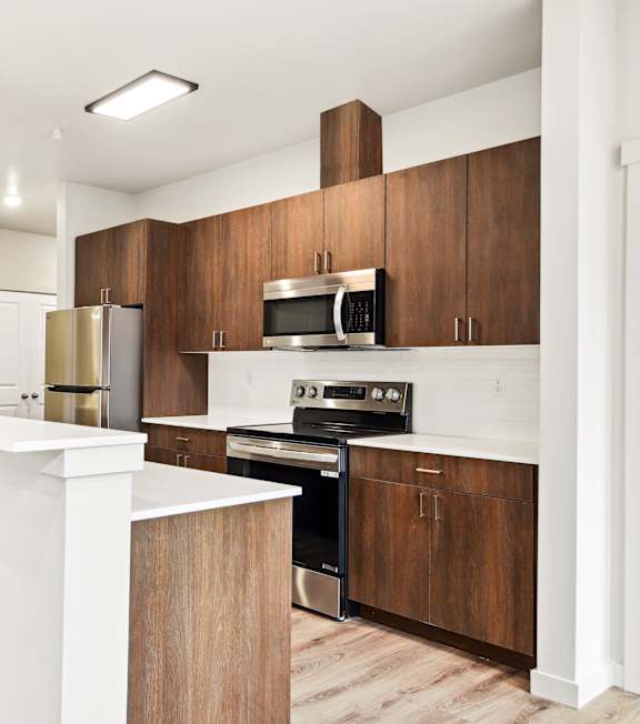 A modern kitchen with wooden cabinets and stainless steel appliances.