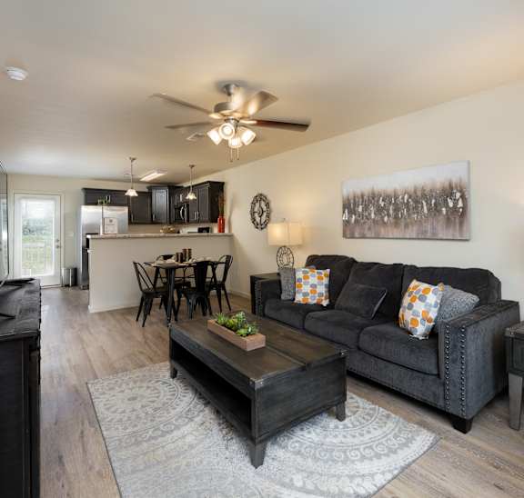 A living room with a grey couch and a wooden coffee table.