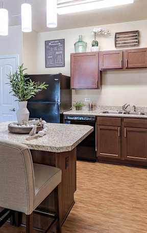 A kitchen with brown cabinets and a table with chairs.