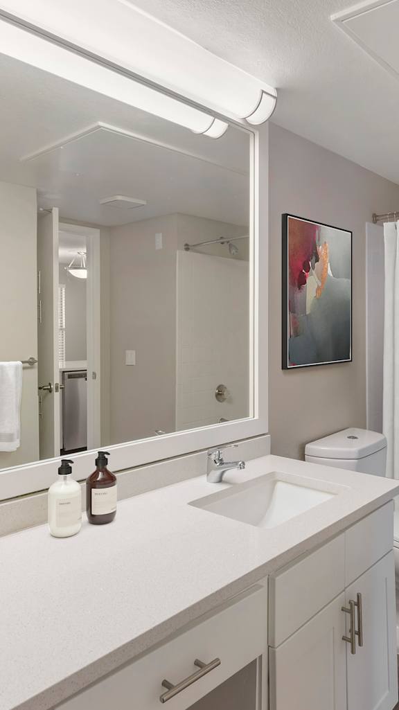 A white bathroom with a toilet, sink, and shower.