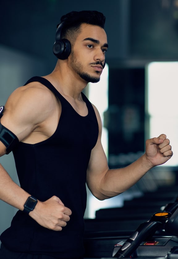 a man running on a treadmill with headphones on
