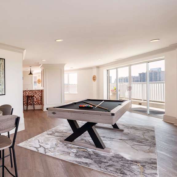 a bar with wooden stools in a room with a pool table