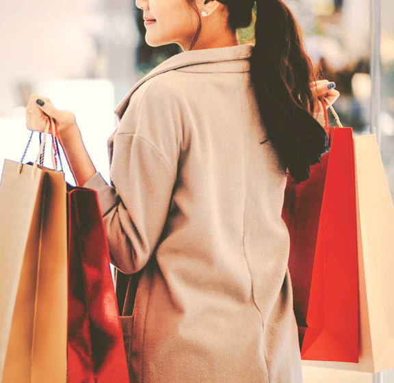 a woman carrying shopping bags in a mall