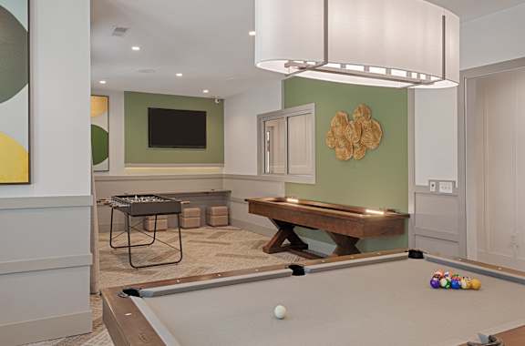 A billiard table is set up in a room with a pool table light.