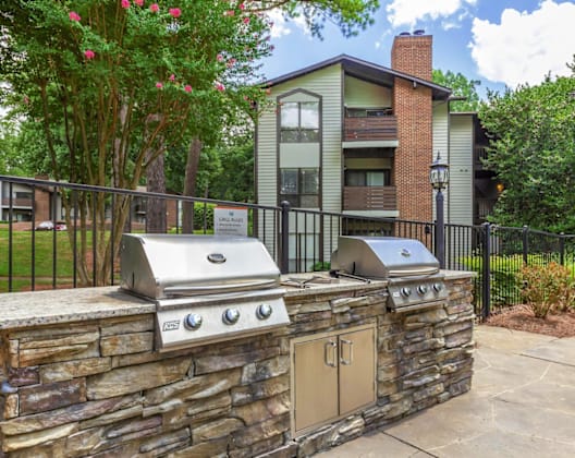 A stone wall with a grill on top of it.