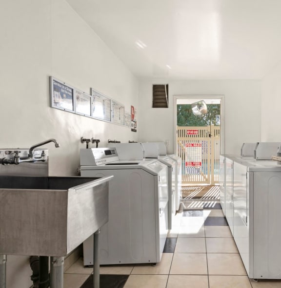 a kitchen with stainless steel sinks and washing machines