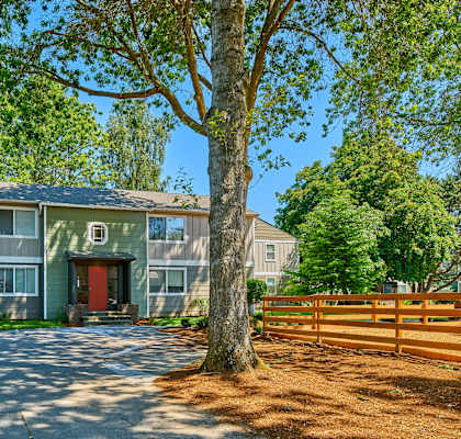 the front of the community building with a large tree in the middle of the driveway.at Woodhaven, Everett, 98203