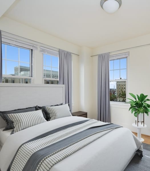 a bedroom with a bed and three windows at 1841 Columbia Road Apartments, Washington, Washington DC