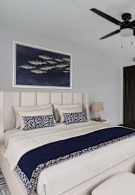 A bedroom with a large bed and a ceiling fan.