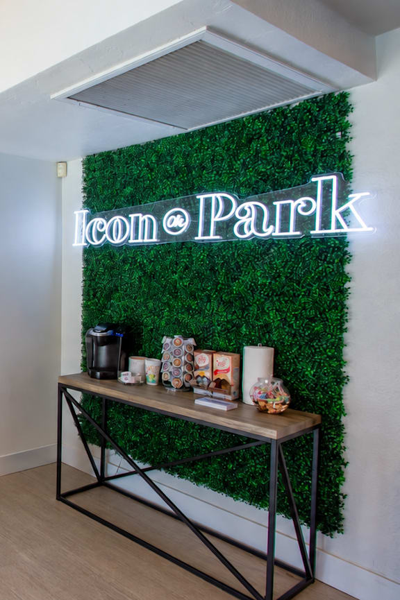 A room with a bench, a mirror, and a green wall with a neon sign that says "loom Park".