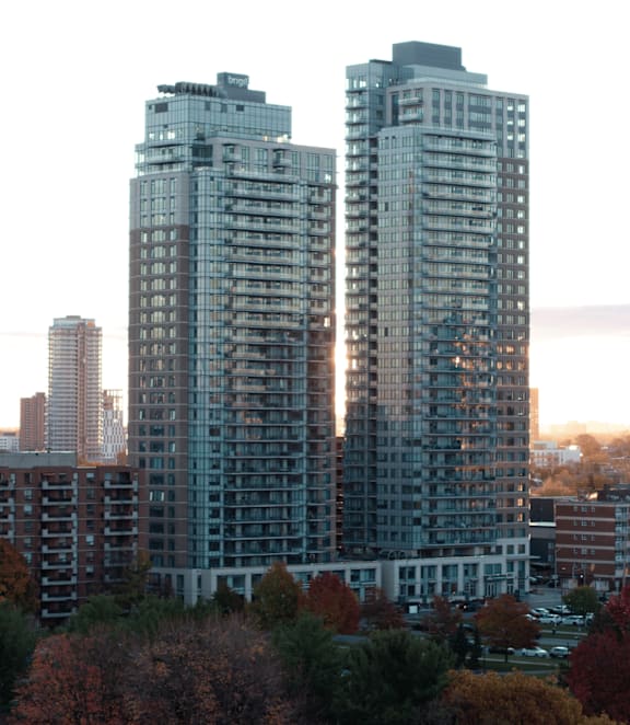 A cityscape with buildings and trees in autumn colors.