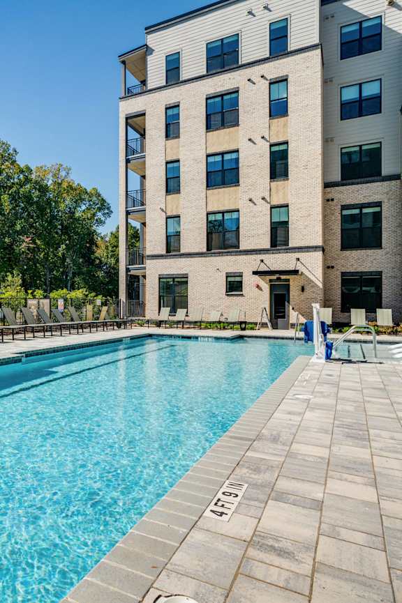 a rendering of a swimming pool in front of an apartment building