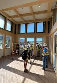 Three construction workers are in a room with wooden floors and walls under construction.at Benedict, The, GLENWOOD SPRINGS, CO