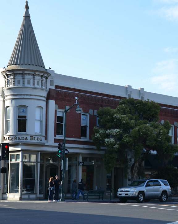A street view with a building that has a steeple on it.