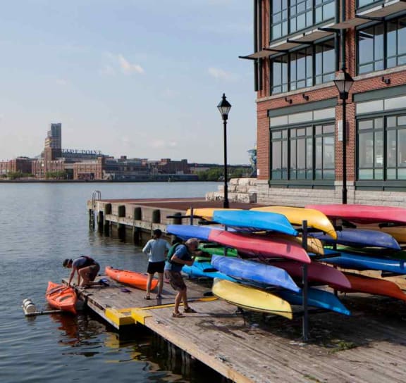 a row of colorful kayaks on a dock in front of a building at 1305 Dock Street, Maryland, 21231