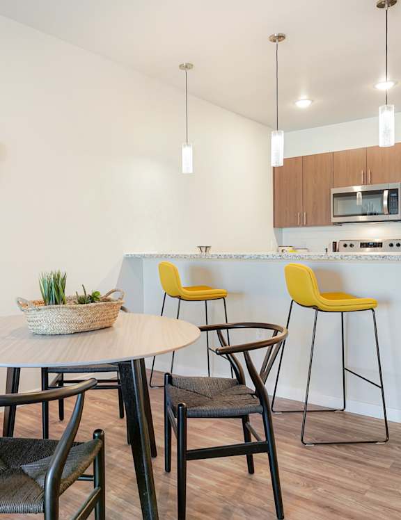 A modern dining room with a round table and chairs.