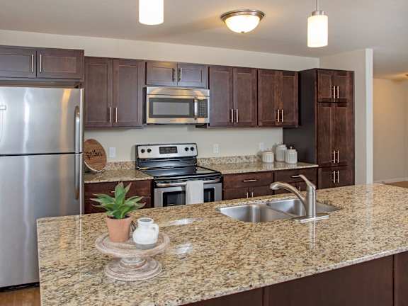 A kitchen with granite countertops and stainless steel appliances.