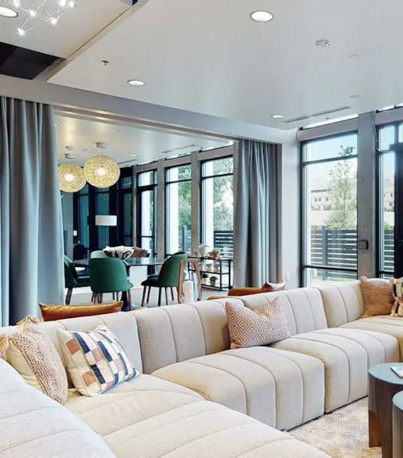 A modern living room with a large sectional sofa and a view of the outdoors.