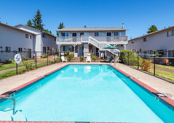 A swimming pool in front of a residential building.
