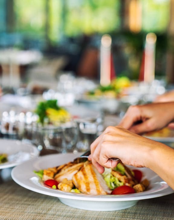 a table with plates of food on it and people sitting around it at Encore Apartments, Ontario, California