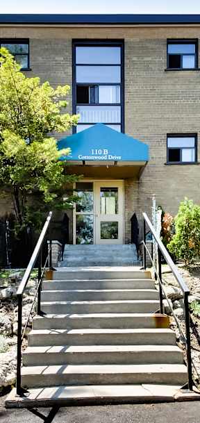 A building with a blue awning and a staircase leading to the entrance.