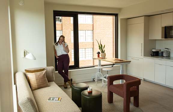 Woman standing in living room at Scout Living, powered by Placemakr, Atlanta