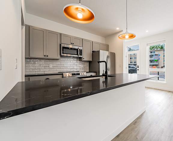 A modern kitchen with a black countertop and stainless steel appliances at Westwood Meadows, Westlake, OH, 44145