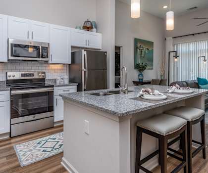 A modern kitchen with a large island and bar stools.