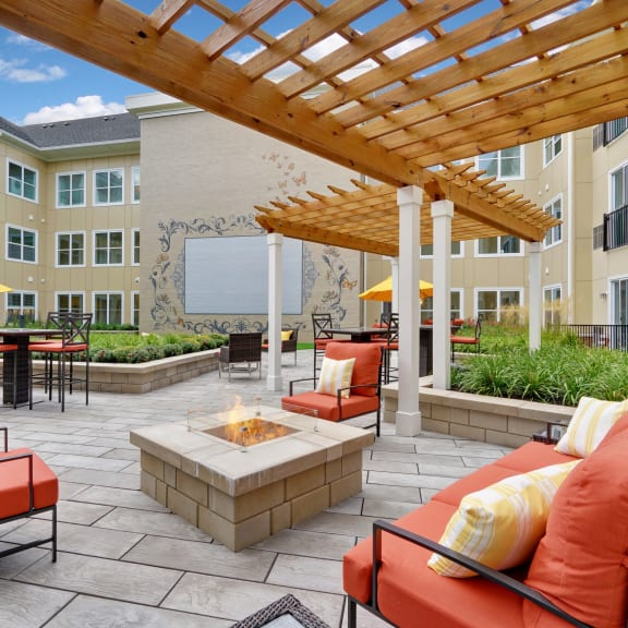 an outdoor patio with couches and a fire pit