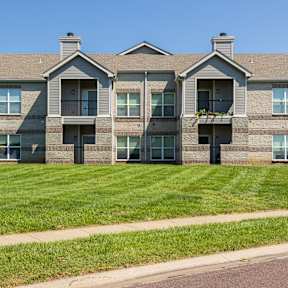 Exterior view of Hawthorne Apartment Homes with landscaped green lawn in Overland Park, Kansas.