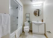 Thumbnail 32 of 33 - A white towel hangs on a glass shower door in a bathroom.
