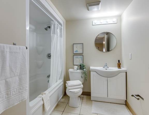 A white towel hangs on a glass shower door in a bathroom.