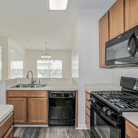 A foosball table is in the middle of a room with a brick fireplace and a chandelier. at Barrington Park Apartments, Manassas