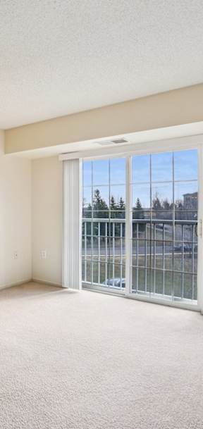 Empty room with a sliding glass door leading to a balcony.