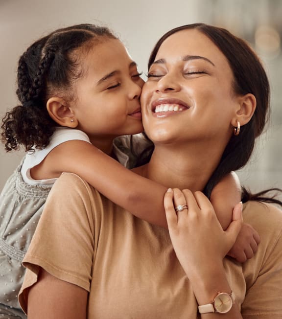 a little girl kissing a woman on her cheek