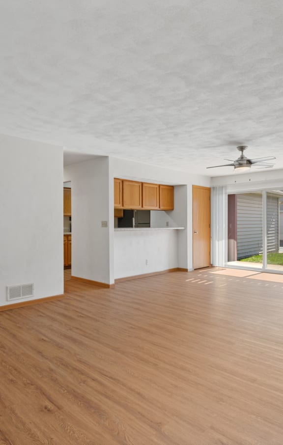 an empty living room with wood floors and white walls