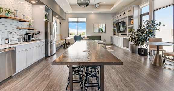 an open kitchen and dining room with a large wooden table