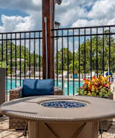 a fire pit with sunflowers in front of the pool at Flats at Sundown apartments