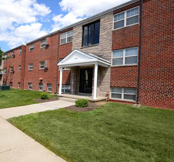 A red brick building with a white entrance at Hyde Park Apartments*, Essex, MD 21221