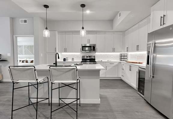 Fully-equipped kitchens with stainless steel appliances, wine coolers and 42" white cabinetry