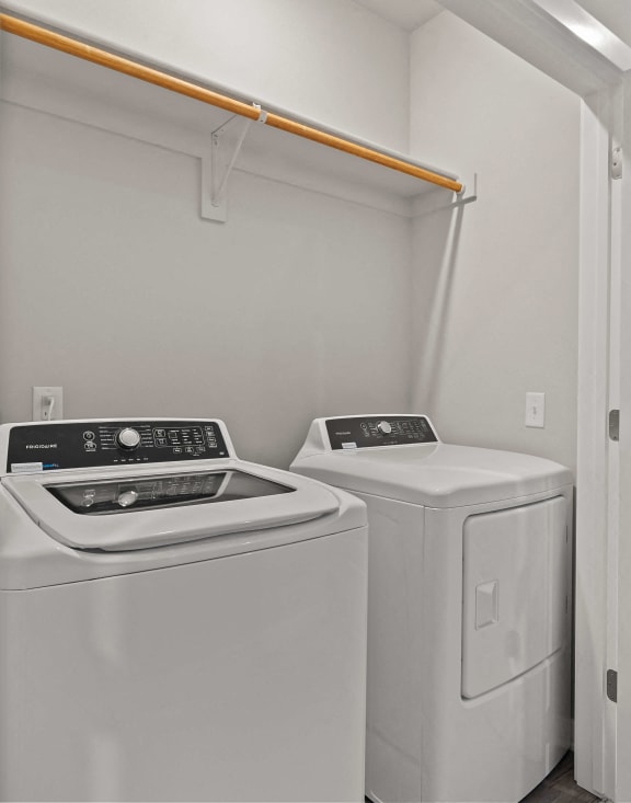 the laundry room has two washer and dryers and a white door at Hillcrest Village, Springdale, AR