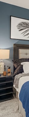 A bedroom with a bed, nightstand, and a ceiling fan.