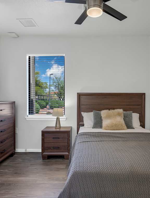 A bedroom with a bed, nightstand, and window.