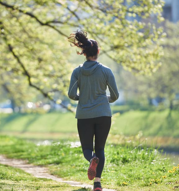 a woman running on a trail in a park
