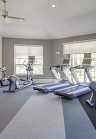 A spacious gym with treadmills and elliptical machines.