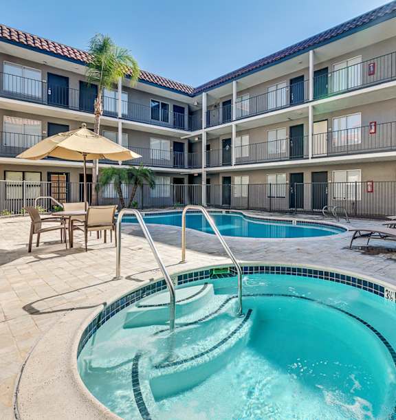 A swimming pool in a courtyard surrounded by apartment buildings.