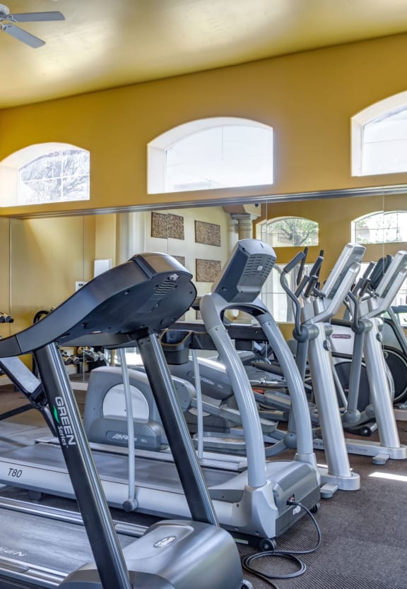 a room filled with cardio equipment and windows at Links at High Resort, Rio Rancho, NM, 87124