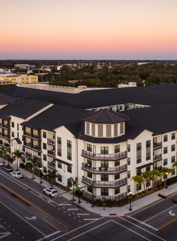 an aerial view of a large apartment complex with a sunset in the background